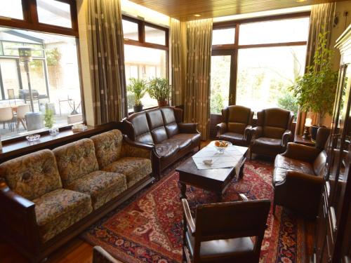 ein Wohnzimmer mit Sofa, Stühlen und Fenstern in der Unterkunft Spacious holiday home in Vicchio with private Pool in Vicchio