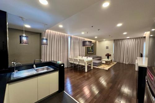 a kitchen and living room with a sink and a couch at Lancaster Hanoi City Center Apartments in Hanoi