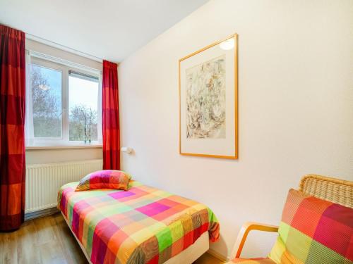 a bedroom with a bed and a window at Homely Apartment in Noordwolde with Balcony in Noordwolde