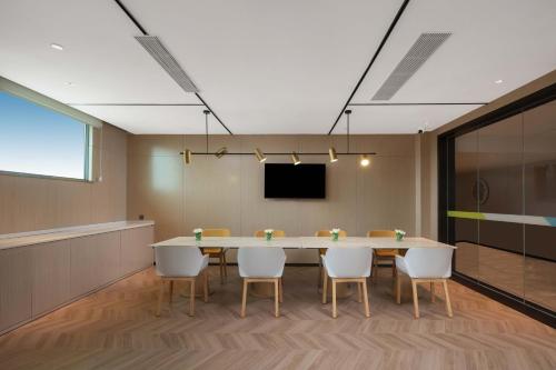a conference room with a table and chairs at Home2 Suite by Hilton Xishuangbanna Jinghong in Jinghong