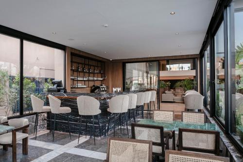 a dining room with a bar with white chairs at NearYo Hotels in Marrakech