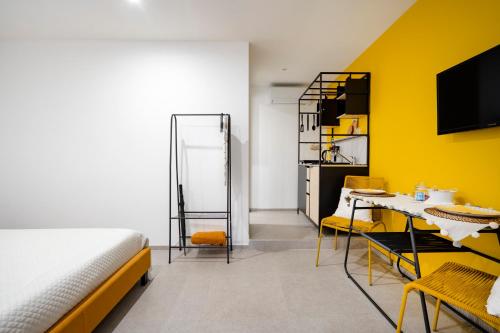 ein Schlafzimmer mit einem Bett und einer gelben Wand in der Unterkunft Dimora dei Colori - Yellow Light in Bari