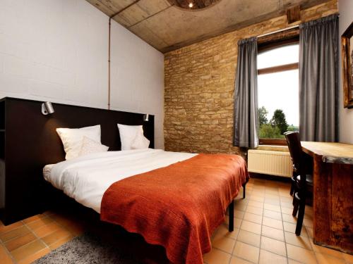 a bedroom with a bed and a desk and a window at Fancy Holiday Home in Sainte-Cécile with Pool House & Indoor Pool in Sainte-Cécile