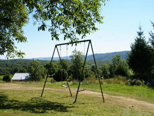 an empty swing set in the middle of a field at Peaceful Mountain Retreat in Neuvéglise