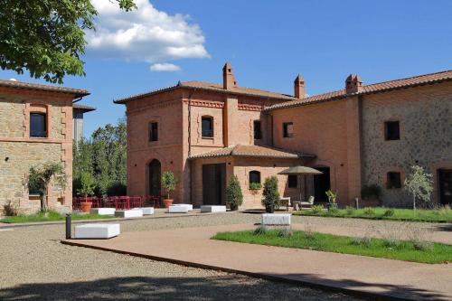 a large brick building with benches in front of it at The Monteleone Umbria Retreat in Monteleone dʼOrvieto