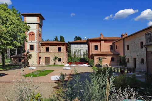 a large building with a clock tower in a courtyard at The Monteleone Umbria Retreat in Monteleone dʼOrvieto