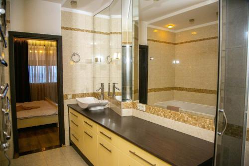 un bagno con lavandino e vasca da bagno di Doba In Ua Most-Sity Apartments a Dnipro