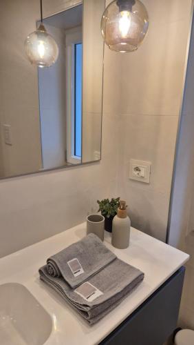 a bathroom with a sink and a mirror and towels at La Casa di Athina 2 in Celano