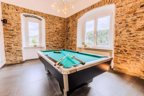 a pool table in a room with brick walls at Villa Klosterschenke Sauna Whirlpool Game Room in Sankt Goarshausen