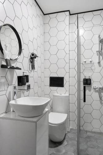 a white bathroom with a sink and a toilet at Sapiens Hotel in Tashkent
