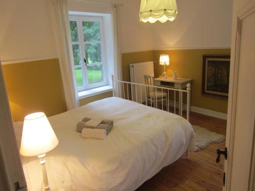 a bedroom with a bed with a lamp and a table at Delightful Castle in Bastogne with bubble bath in Bastogne