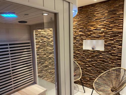 a lobby with two chairs and a brick wall at Delightful Castle in Bastogne with bubble bath in Bastogne