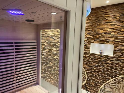a glass door of a building with a brick wall at Delightful Castle in Bastogne with bubble bath in Bastogne