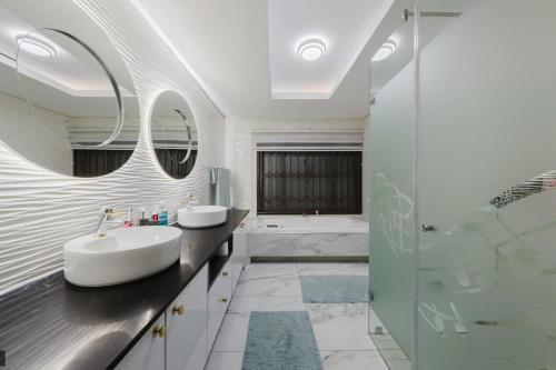 a bathroom with two sinks and a shower at Private Villa-Views, Pool, Braai in Johannesburg