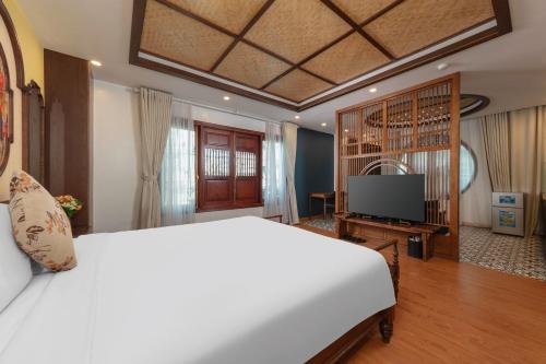a bedroom with a white bed and a television at Veshia Hotel & Spa in Hanoi