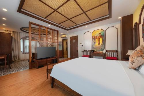 a bedroom with a white bed and a flat screen tv at Veshia Hotel & Spa in Hanoi