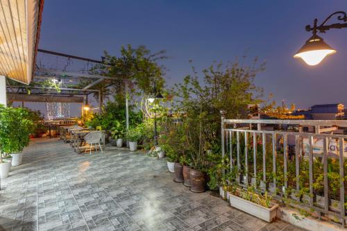 a patio with potted plants and a table and chairs at Veshia Hotel & Spa in Hanoi
