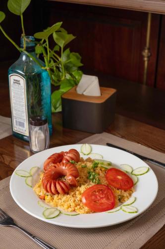 a plate of food with tomatoes and rice on a table at Veshia Hotel & Spa in Hanoi