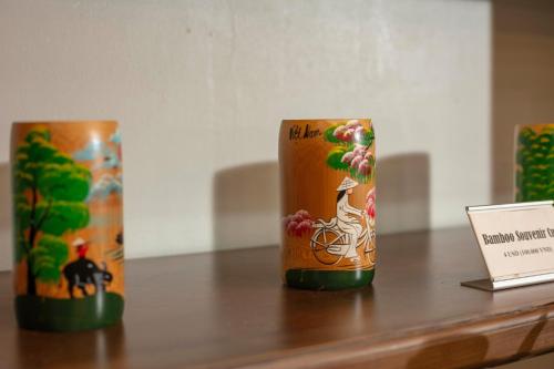 three canisters sitting on top of a wooden table at Veshia Hotel & Spa in Hanoi