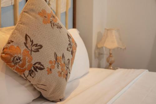 a pillow sitting on a bed next to a lamp at Veshia Hotel & Spa in Hanoi