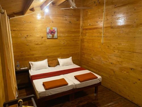 una camera da letto con un letto in una stanza di legno di Trekkingtrails woodhouse a Jāmb