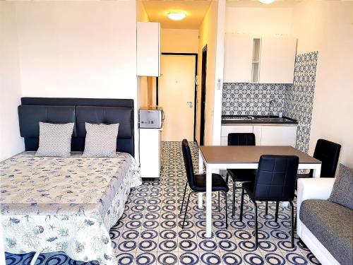 ein Schlafzimmer mit Bett und Tisch und eine Küche in der Unterkunft Snug holiday home in Porto Santa Margherita with terrace in Porto Santa Margherita