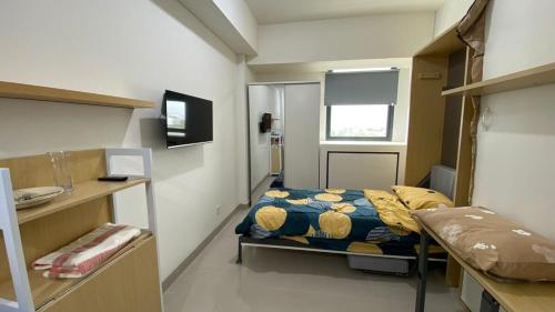a small room with a bed and a window at Bandaraya Apartment Tallasa City 10B21 By Millpro in Pacinongong
