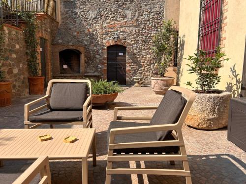 a patio with two chairs and a table and a table at Dimora 1848 - Foresteria Lombarda in Volta Mantovana