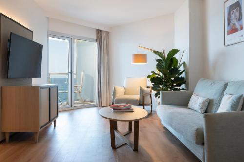 a living room with a couch and a tv and a table at INNSiDE by Meliá Alicante Porta Maris in Alicante