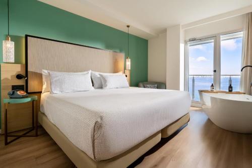 a bedroom with a large bed and a bath tub at INNSiDE by Meliá Alicante Porta Maris in Alicante