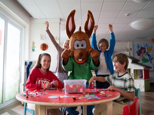 a group of children sitting around a table with a person in a costume at Apartments in the holiday and leisure park Weissenhäuser Strand, Weissenhäuser Strand in Weissenhäuser Strand