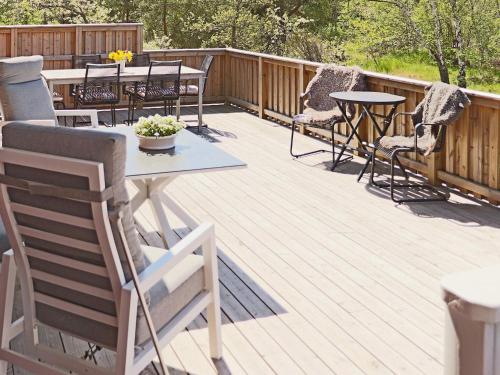 a wooden deck with tables and chairs on it at 6 person holiday home in Slöinge in Slöinge