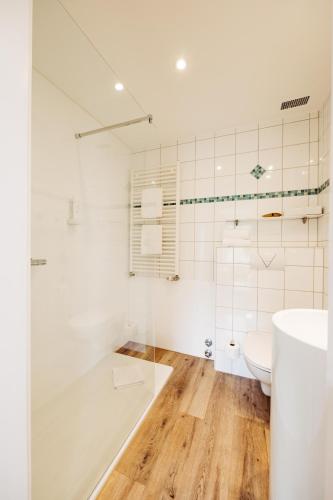 a white bathroom with a tub and a toilet at Berghotel Hoher Knochen - Ruhe & Natur in Winterberg
