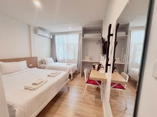 a small room with two beds and a table and a couch at K Home Asok in Bangkok