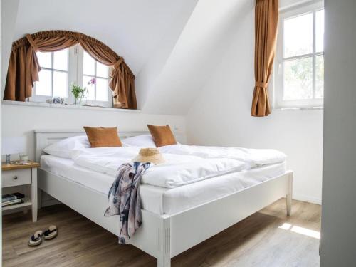 a bedroom with a white bed with a mirror at Apartment, Zingst in Zingst