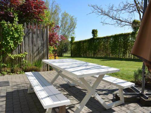 a white picnic table and bench in a backyard at Cottage with Foosball & Garden in Jehonville