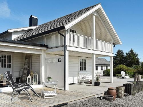 a white house with a deck and a chair at 10 person holiday home in Tornes I Romsdal in Tornes