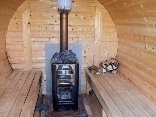 a stove in a wooden room with two benches at 10 person holiday home in Tornes I Romsdal in Tornes