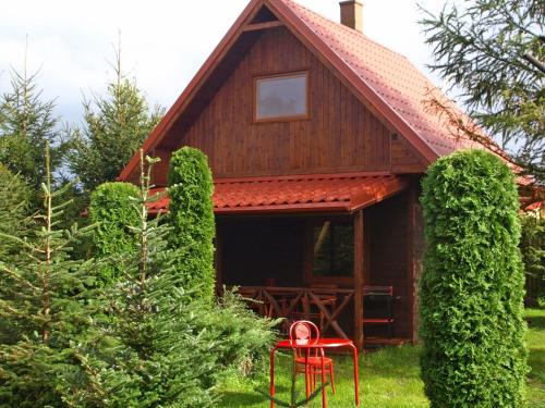 a house with a red chair in front of it at Authentic Holiday Home in Kopalino with Fireplace in Kopalino