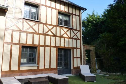 a building with a bench and a chair in front of it at Semi-detached house, Rieux in Rieux