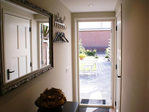 a mirror hanging on a wall next to a door at Atmospheric Wadden houses located next to each other near the Wadden Sea in Paesens