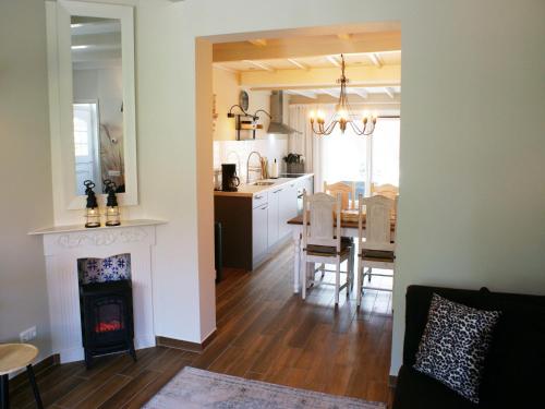 a kitchen and living room with a fireplace and a table at Atmospheric Wadden houses located next to each other near the Wadden Sea in Paesens