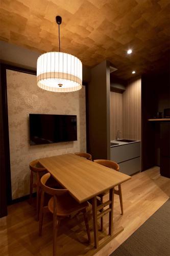 a dining room with a wooden table and a chandelier at Hotel Matsunoi Shurin in Tokyo