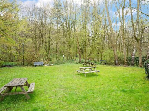 two picnic tables and benches in a park at Chalet in Ulestraten near Maastricht in Ulestraten