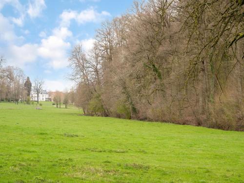 a field with green grass and trees in the distance at Chalet in Ulestraten near Maastricht in Ulestraten