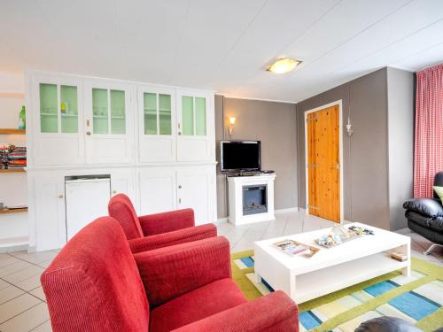 a living room with a red couch and a coffee table at Chalet in Ulestraten near Maastricht in Ulestraten