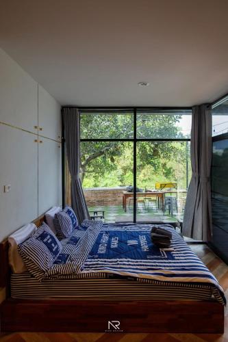 a bed in a room with a large window at The Canale Hat Yai in Songkhla