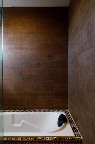 a bath tub in a bathroom with a glass shower at The Canale Hat Yai in Songkhla