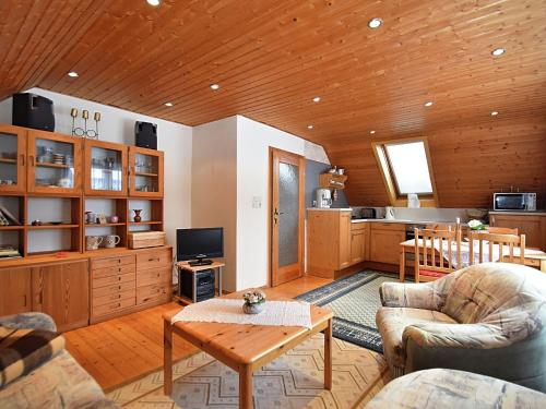 a living room with a table and a kitchen at Einladende Ferienwohnung mit Außenpool in Beerheide