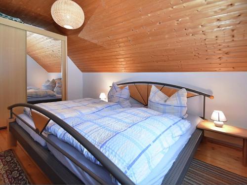 a bedroom with a bed with a wooden ceiling at Einladende Ferienwohnung mit Außenpool in Beerheide